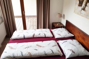 2 Betten in einem kleinen Zimmer mit Fenster in der Unterkunft Ferienwohnung Resort Walensee 98 - Seehöckli in Quarten