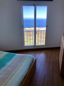 a bedroom with a large window with a view of the ocean at Vv Bimba in Frontera