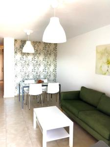 een woonkamer met een groene bank en een tafel bij Vv Bimba in Frontera
