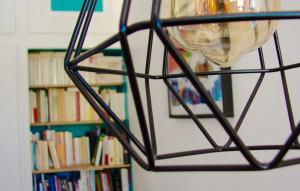 una bola de metal colgada de una pared junto a un estante de libros en Maison Les greniers, en Myon
