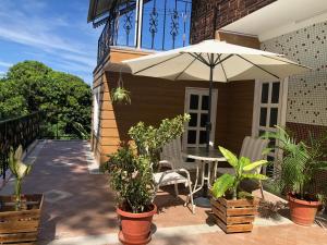 une terrasse avec une table et un parasol dans l'établissement Cozy House, à Beau Bassin-Rose Hill