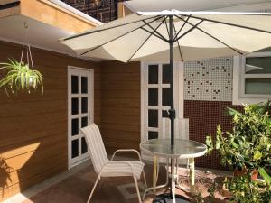 a table and chairs under an umbrella on a patio at Cozy House in Rose Hill