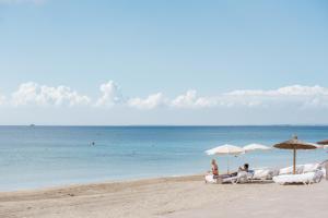 
people sitting on top of a sandy beach at Hotel Garbi Ibiza & Spa in Playa d'en Bossa
