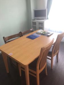 a wooden table with two chairs and a television at 札幌市中心部大通公園まで徒歩十分観光移動に便利なロケーションh703 in Sapporo