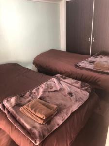 two beds in a room with a towel on them at 札幌市中心部大通公園まで徒歩十分観光移動に便利なロケーションh703 in Sapporo