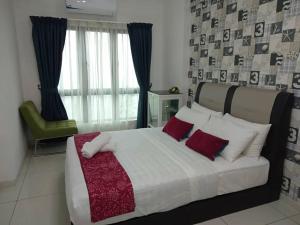 ein Schlafzimmer mit einem großen Bett mit roten und weißen Kissen in der Unterkunft Luxury Homestay at Emira Residence in Shah Alam