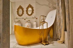 a yellow tub in a bathroom with two mirrors at Chateau du Bec du Gave in Port-de-Lanne