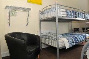 a bedroom with a bunk bed and a black chair at The Hostel in Edinburgh