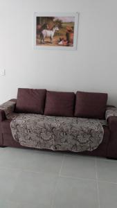 um sofá castanho num quarto com uma fotografia na parede em Plaza Fraga Maia em Feira de Santana