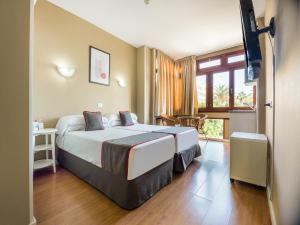 una camera d'albergo con un grande letto e una finestra di Miami Santa Catalina a Las Palmas de Gran Canaria