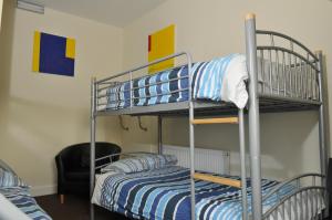 a bunk bed room with two beds and a chair at The Hostel in Edinburgh