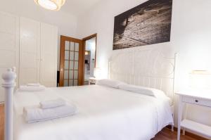 uma cama branca com duas toalhas em cima em Cozy Central Flat - Porta Romana - Duomo em Milão