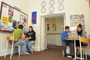 a group of people sitting at tables with laptops at The Hostel in Edinburgh