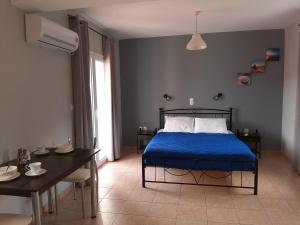 Schlafzimmer mit einem Bett mit blauer Tagesdecke in der Unterkunft Rodanthy Studios IV in Kateliós