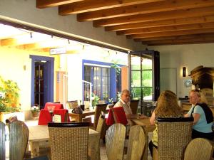 a group of people sitting at a table in a restaurant at Cleo´s Hotel Kallstadt in Kallstadt
