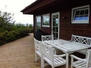 una terraza de madera con mesa y sillas en una casa en Loff Holiday Houses, en Aabenraa