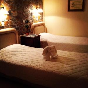 um elefante de peluche sentado numa cama num quarto de hotel em Litsa em Plomari