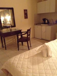 um quarto com uma cama, uma secretária e uma cozinha em Litsa em Plomari