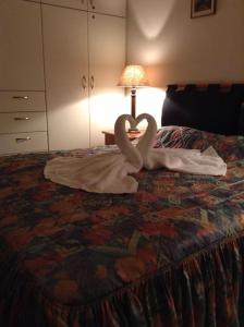 dois cisnes feitos de toalhas numa cama em Litsa em Plomari