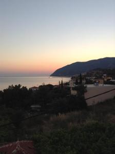 vista para o oceano ao pôr-do-sol com uma cidade em Litsa em Plomari
