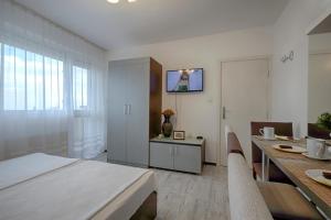 ゴールデン・サンズにあるKabakum Apartments Alen Makの白い部屋(ダイニングテーブル、ベッド付)