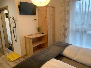 a bedroom with a bed and a television in a room at Apart Wexwood in Hart im Zillertal