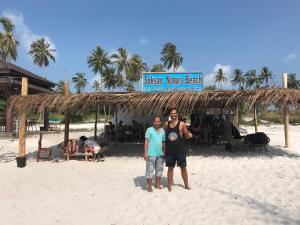 a man and a boy standing on the beach at Soksan Natura Beach in Koh Rong Island