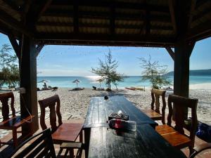 瓜隆岛Soksan Natura Beach的海滩上的木桌,享有海景