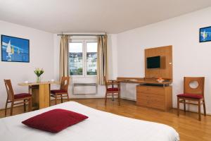 Habitación de hotel con cama, escritorio y mesa. en Séjours & Affaires Lyon Saxe-Gambetta, en Lyon