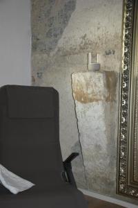 a black chair in front of a wall with a mirror at Residenz Nr.6 in Zapfendorf