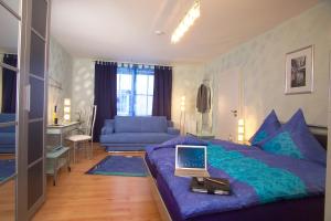 a bedroom with a purple bed with a laptop on it at Cleo´s Hotel Kallstadt in Kallstadt