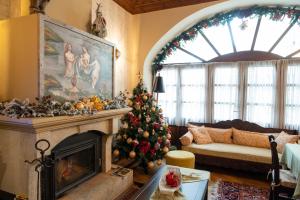 a living room with a christmas tree in front of a fireplace at Kaza Guesthouse in Dimitsana