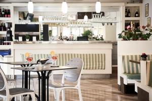 a restaurant with two tables and chairs and a bar at Hotel Villa Roma in Caorle