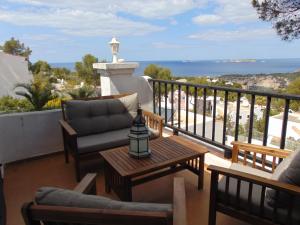 patio z krzesłami i stołem na balkonie w obiekcie Casa Sol & Mar w mieście San Jose de sa Talaia