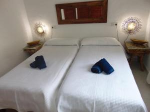 Dos camas en una habitación con almohadas azules. en Casa Sol & Mar, en Sant Josep de sa Talaia