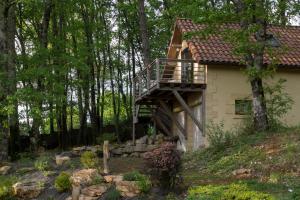 CastelsにあるStudio cosy perché dans les arbres au coeur du Périgord proche Sarlatの木製のデッキ付きの家