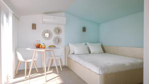 a bedroom with a white bed and white walls at Résidence Mobydick in Porto-Vecchio