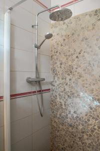 eine Dusche in einem Badezimmer mit einer Steinwand in der Unterkunft Studio cosy perché dans les arbres au coeur du Périgord proche Sarlat in Castels + 16 Fotos