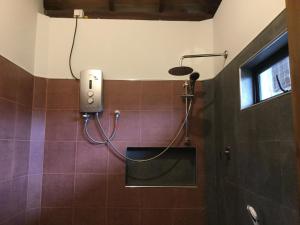 łazienka z prysznicem wyłożona fioletowymi kafelkami. w obiekcie Tranquality Chalets w Tangalli