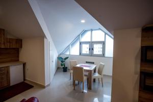 a dining room with a table and chairs and a window at City Center Apartments in Pirot