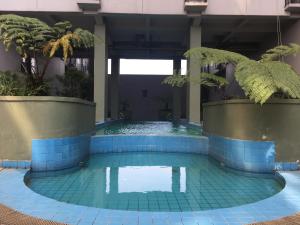 basen z niebieskimi płytkami w budynku w obiekcie Stylish Studio Room Grand Asia Afrika Apartment By Travelio w mieście Bandung