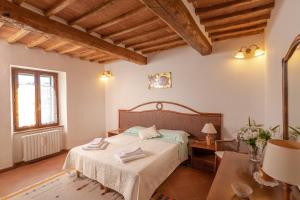 1 dormitorio con 1 cama en una habitación con techos de madera en Villa La Casa del Re, en Le Piazze
