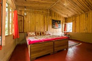 1 dormitorio con 1 cama en una habitación de madera en Rishikesh Valley, en Rishīkesh