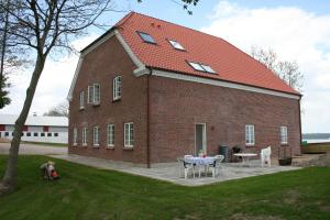 a large brick building with a table in front of it at Loff Holiday Houses in Aabenraa