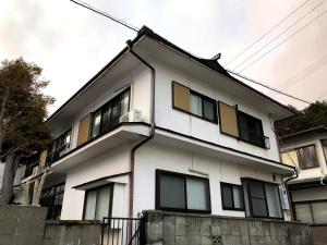 un edificio blanco con ventanas laterales en Guest House hachi hachi, en Koyasan