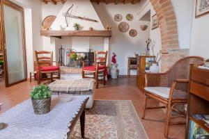 a living room with tables and chairs and a fireplace at Villa La Casa del Re in Le Piazze