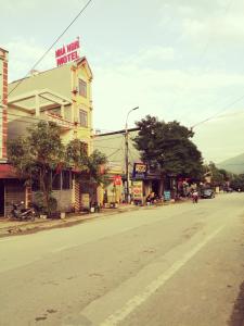 una calle con un edificio amarillo al lado de la carretera en Yen Minh Hotel Thien An en Na Thôn