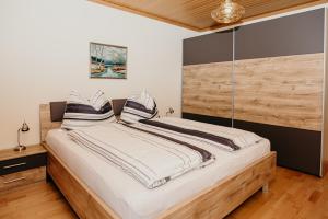 une chambre avec un grand lit avec une tête de lit en bois dans l'établissement Ferienwohnung Hartlieb Goldeck Millstättersee, à Spittal an der Drau