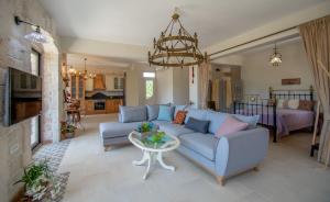 a living room with a blue couch and a table at Villa Olga in Kalamaki