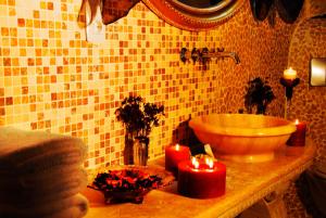 baño con lavabo y 2 velas en una encimera en Perimasali Cave Hotel - Cappadocia, en Ürgüp